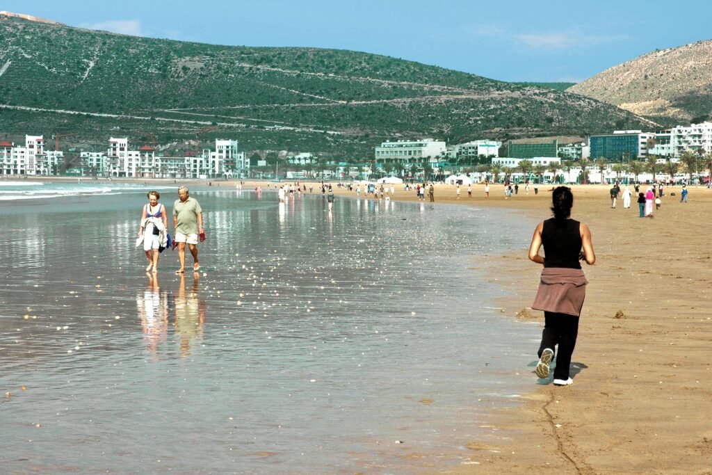 People enjoying a sunny day at a beautiful beach in Agadir, Morocco.